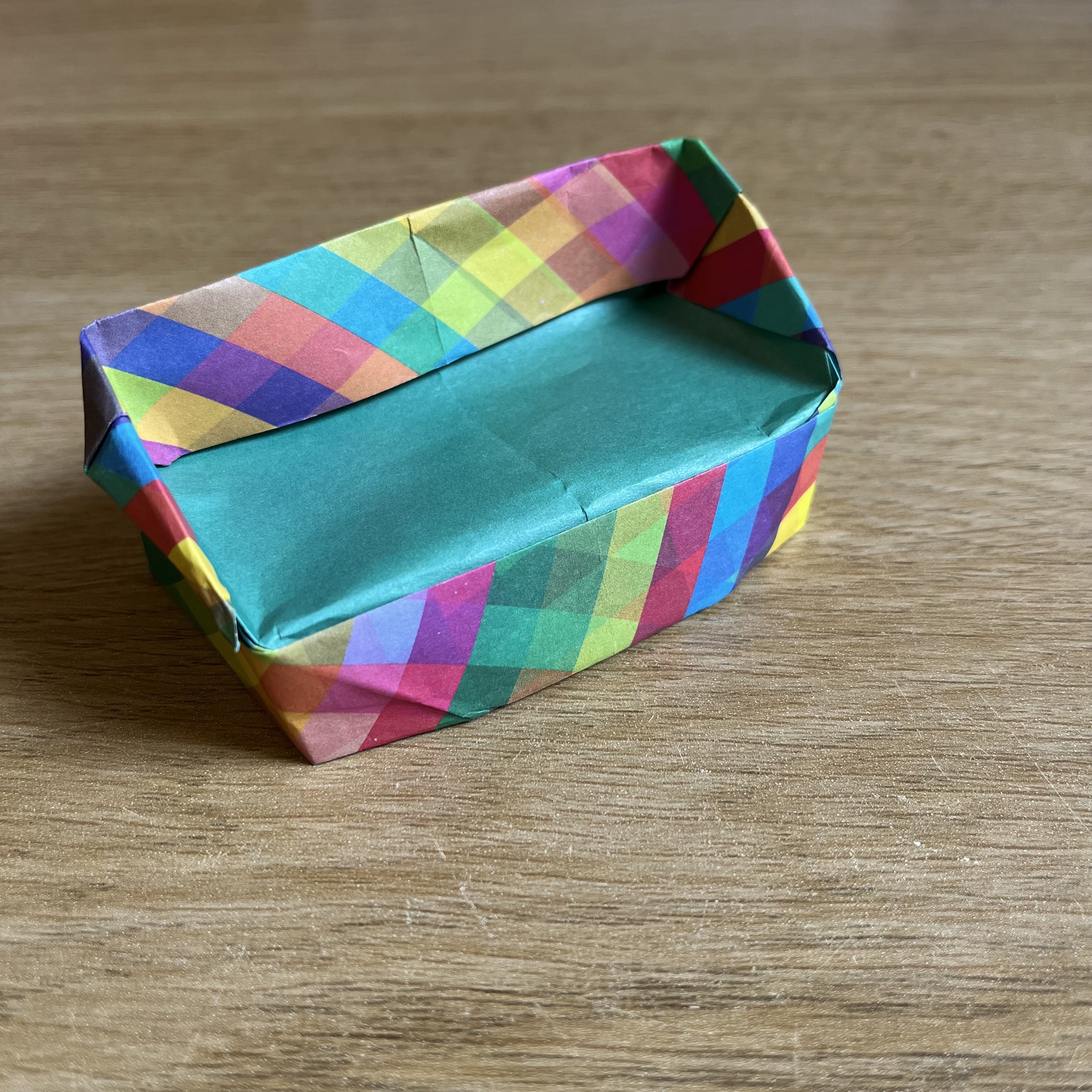 An origami box sitting on top of a wooden table.